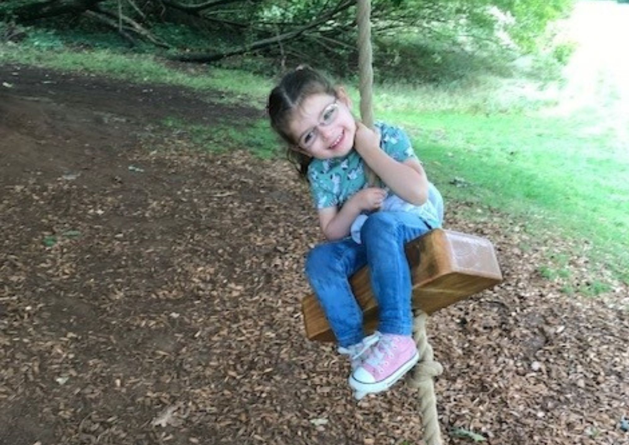 Amelia smiling on swing