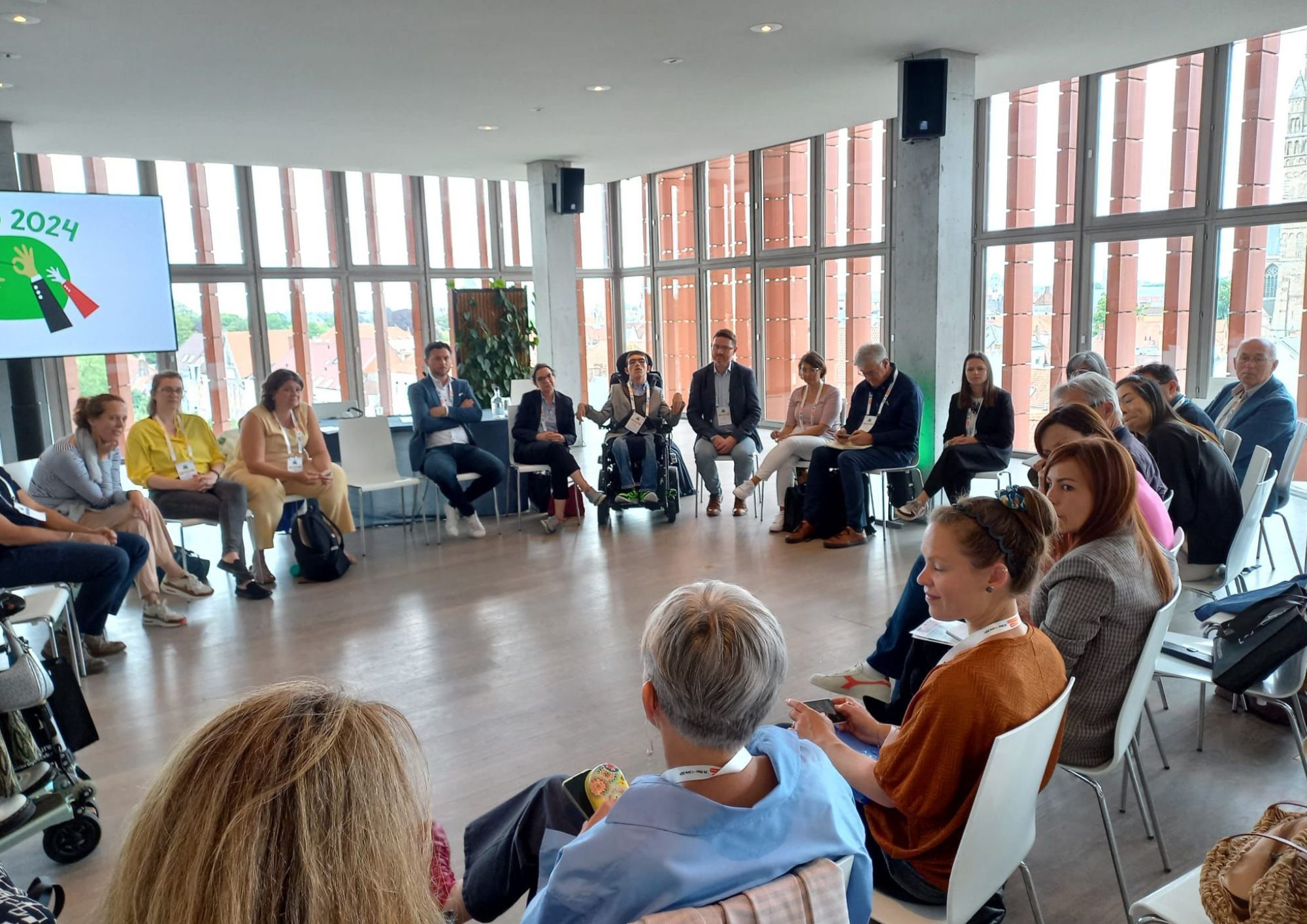 a group of people sitting in a circle in discussion