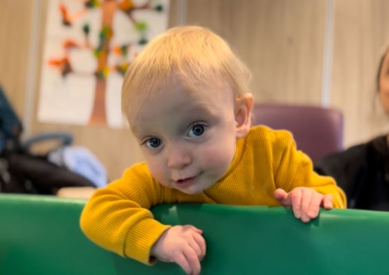 Photograph of baby looking up at camera.