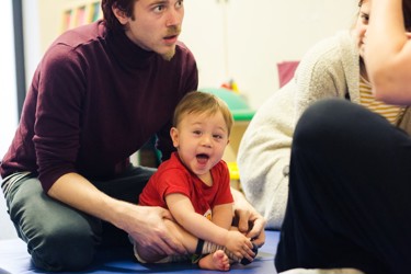 baby smiling with his father