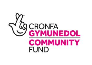 National Lottery Community Fund logo. Pink and white text reading Community Fund in English and Welsh. On the left is a fingers crossed icon with a smiley face.