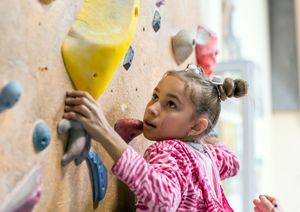 young girl using a climbing wall