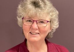 Photograph of one of our occupational therapists in front of purple wall.